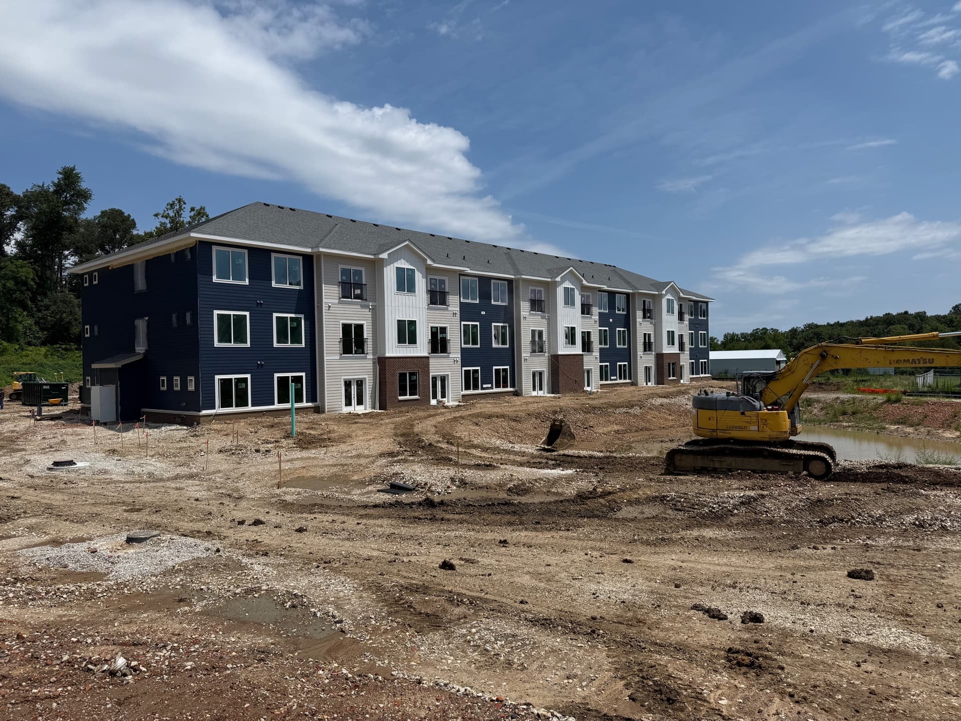 Finished exterior of an Oak Street Village apartment building with sitework underway